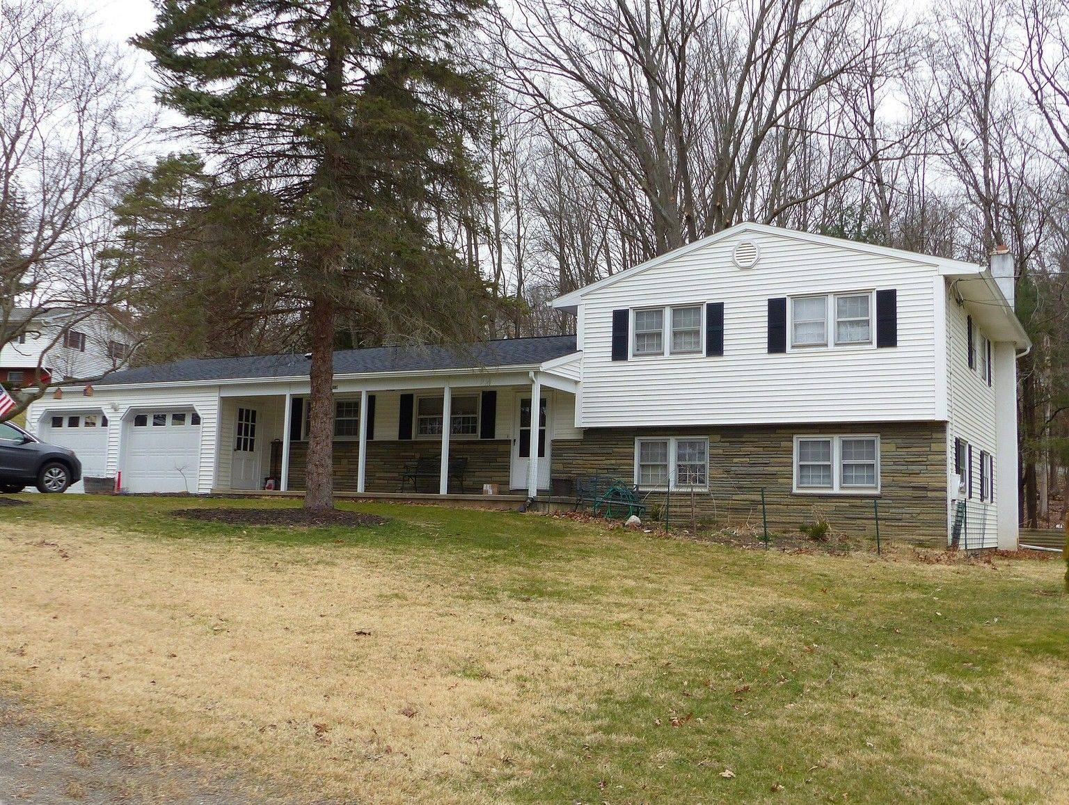 A white split-level house with black shutters.